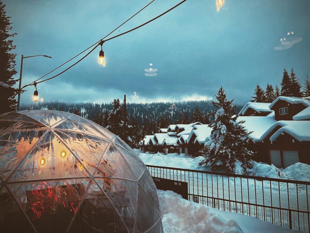 A private heated igloo for winter dining at Wildflour, strung with lights.